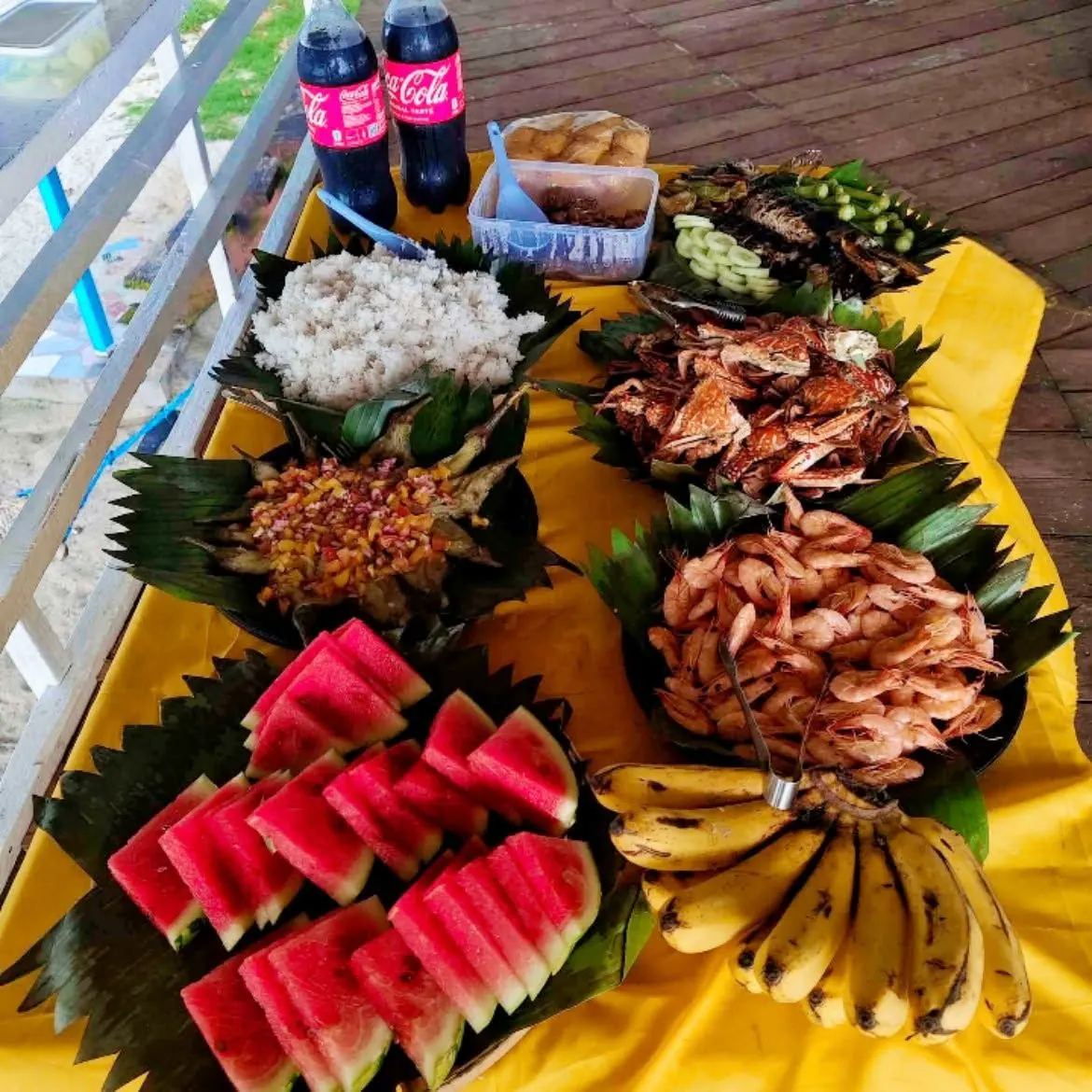 A boodle lunch of grilled fish, seafood, rice, watermelon and bananas