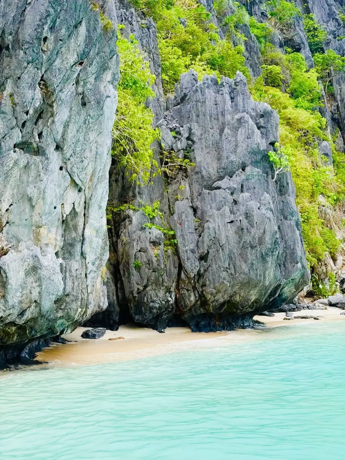 Turquoise water at the foot of a limestone cliff