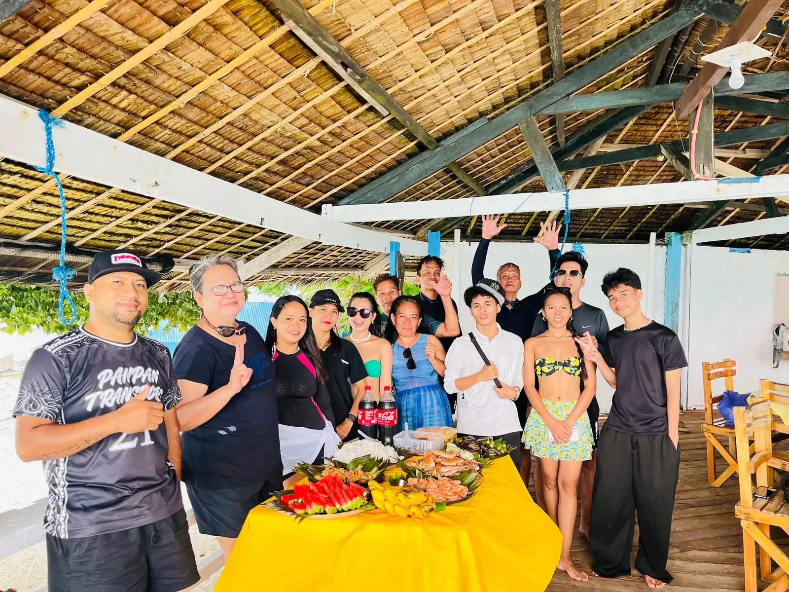 A happy tour group at a seaside lunch spread