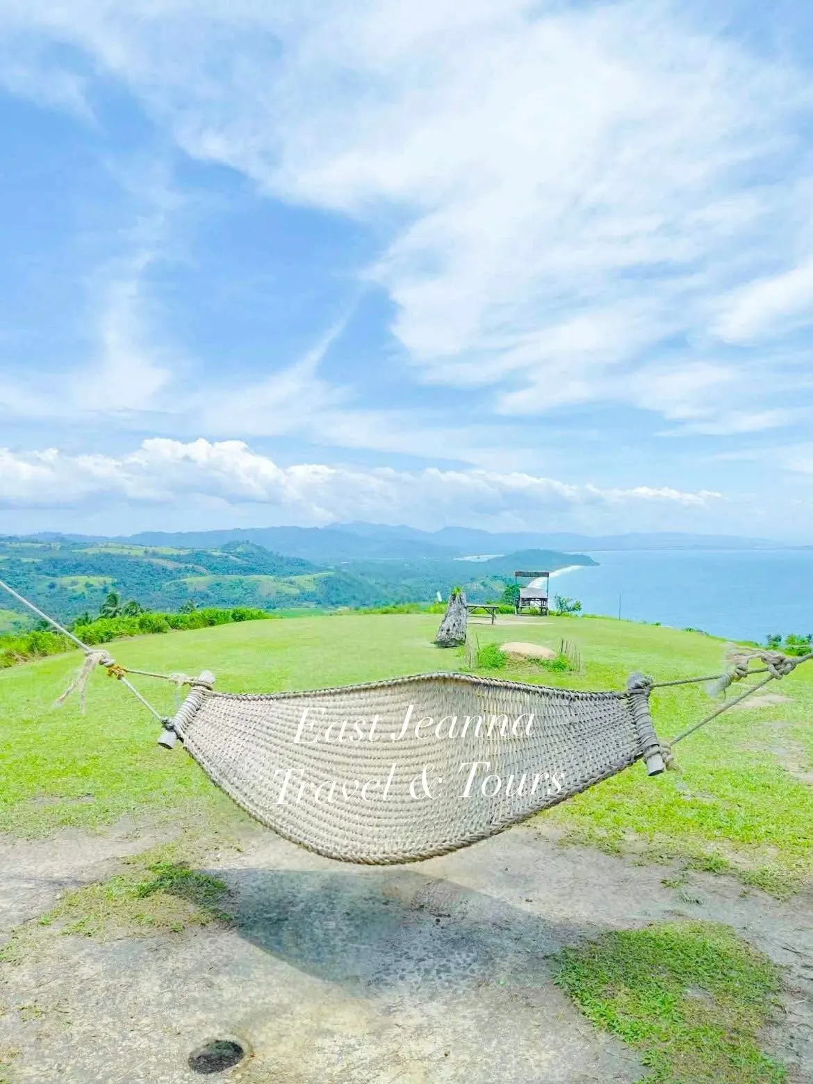 A hammock on a grassy hilltop above the sea