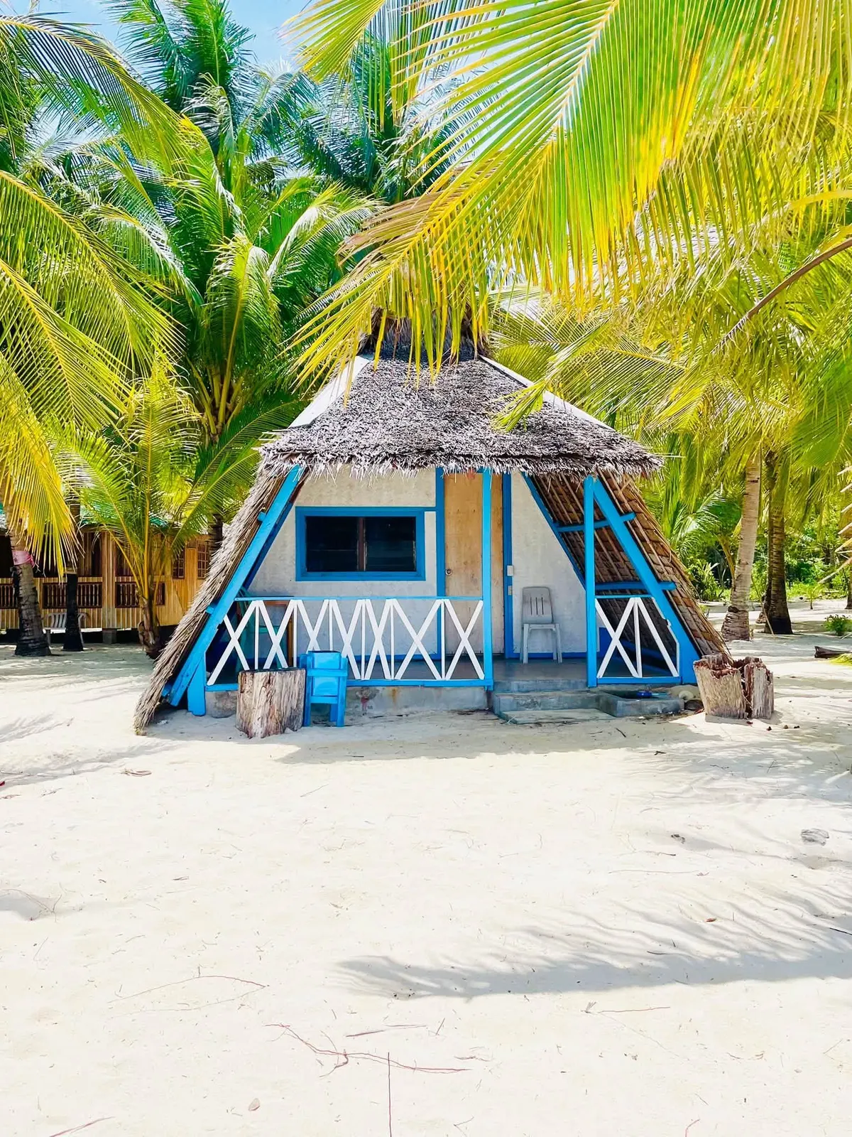 A blue-trimmed nipa hut on the beach