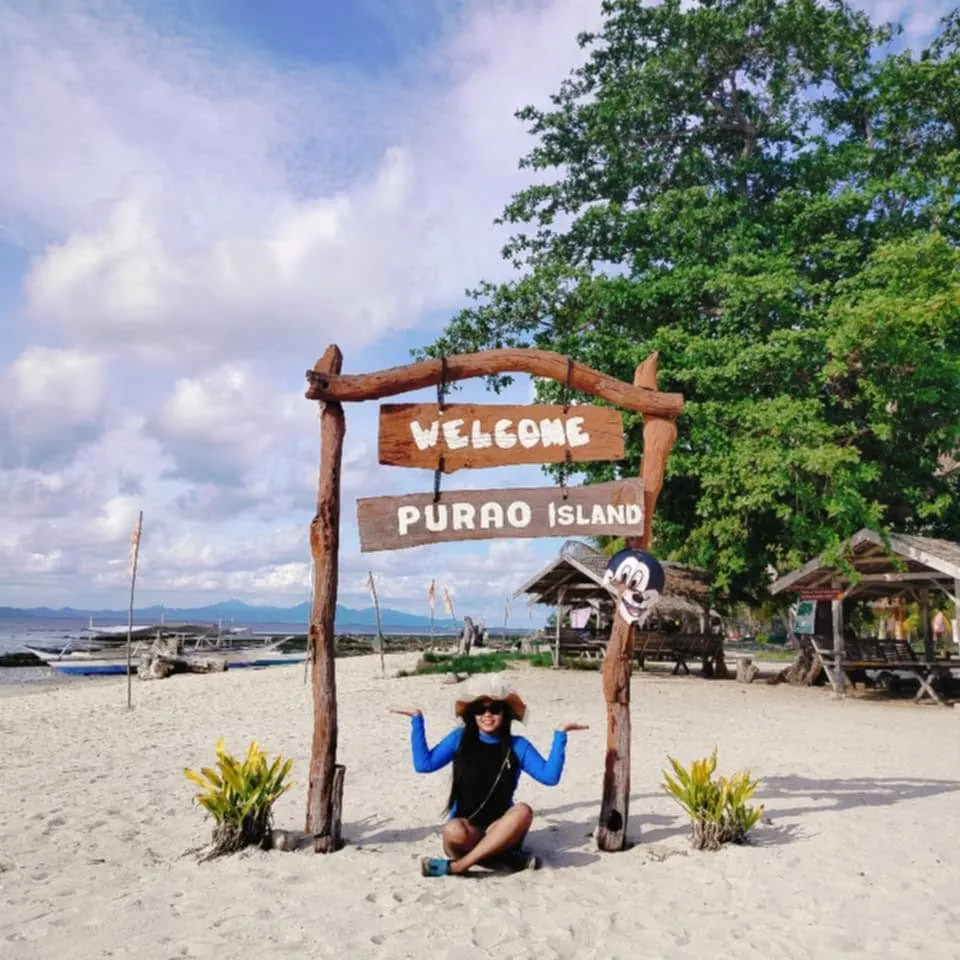 The Welcome to Purao Island sign on the beach